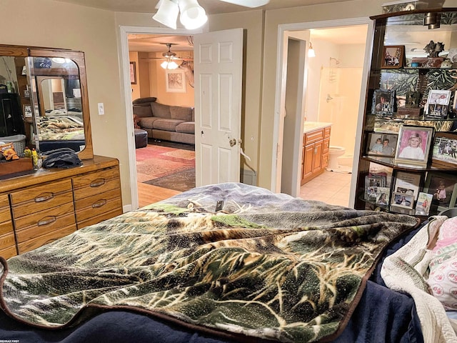 bedroom featuring connected bathroom and light tile patterned flooring