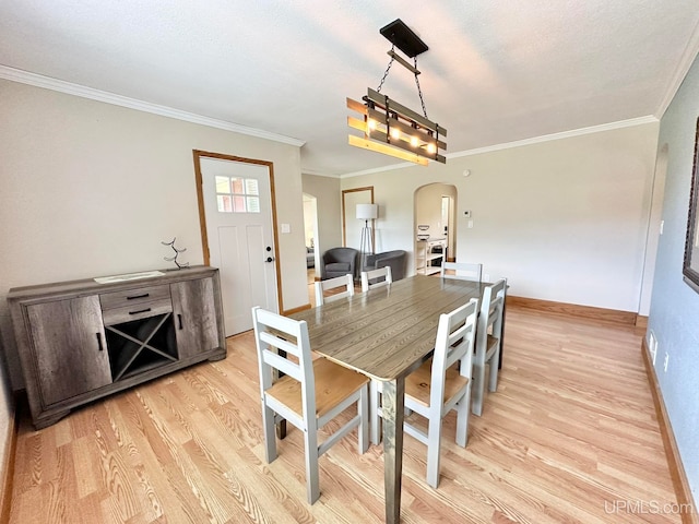 dining room with crown molding and light hardwood / wood-style flooring