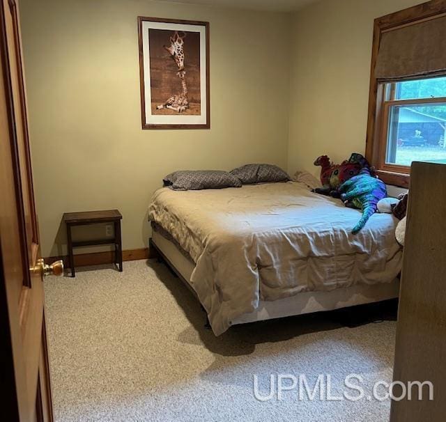 carpeted bedroom featuring baseboards