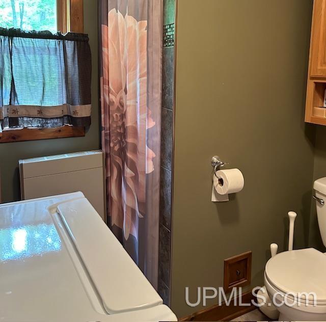 bathroom featuring toilet and a shower with shower curtain