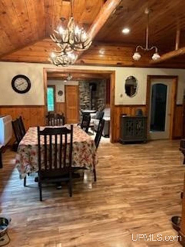 dining area with an inviting chandelier, wooden ceiling, wood-type flooring, and vaulted ceiling