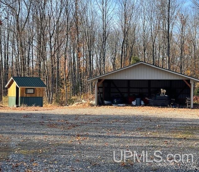 exterior space with an outbuilding, an outdoor structure, and a view of trees