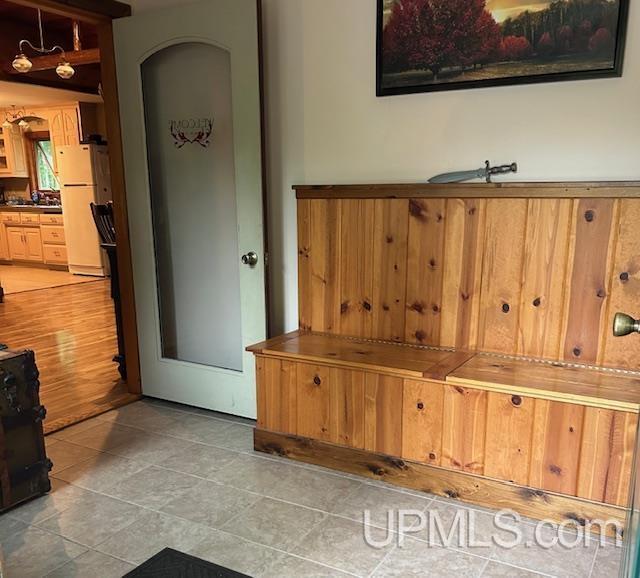 mudroom featuring arched walkways and light tile patterned floors