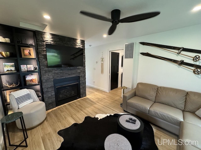living room featuring recessed lighting, light wood-type flooring, ceiling fan, visible vents, and a fireplace