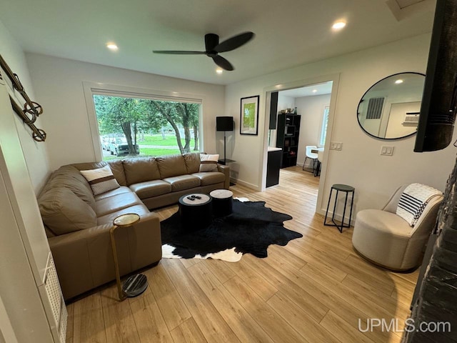 living room with ceiling fan and light hardwood / wood-style flooring