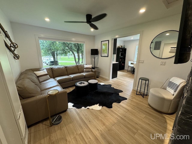 living room featuring baseboards, light wood-style flooring, recessed lighting, and a ceiling fan