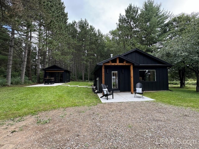 back of property featuring a patio, board and batten siding, and a yard