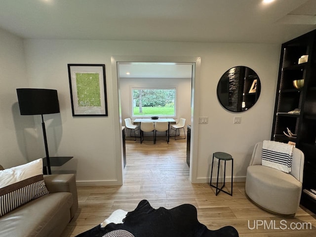 living area featuring light wood-style flooring and baseboards