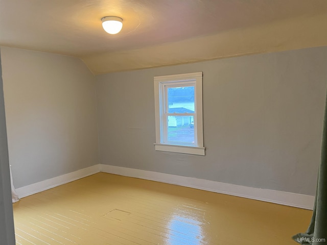 unfurnished room with lofted ceiling and hardwood / wood-style flooring