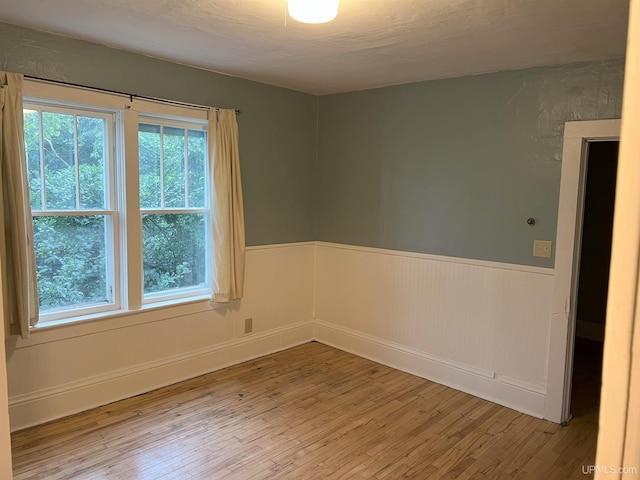 empty room with a healthy amount of sunlight and hardwood / wood-style flooring