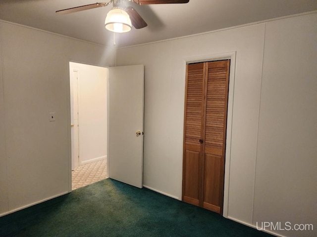 unfurnished bedroom featuring dark tile patterned flooring, ceiling fan, and a closet