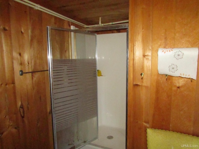 bathroom featuring a shower and wood walls