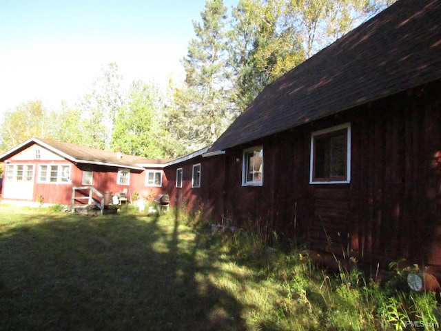 view of side of home with a yard