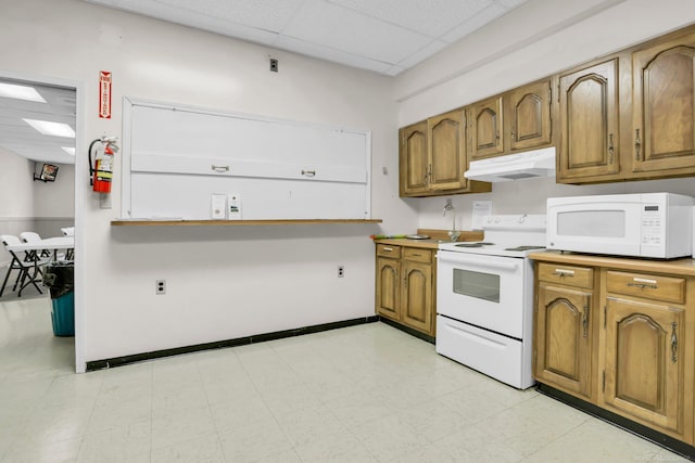 kitchen with white appliances and a drop ceiling