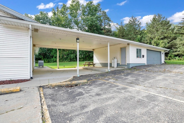 exterior space featuring an outdoor structure, a garage, a front yard, and a carport