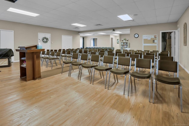 misc room with a paneled ceiling and light hardwood / wood-style floors