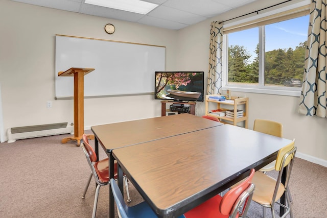 carpeted dining space with baseboard heating and a drop ceiling