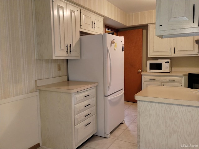 kitchen with white appliances and light tile patterned floors