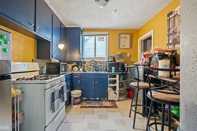 kitchen featuring a textured ceiling, blue cabinets, sink, and white range with gas cooktop