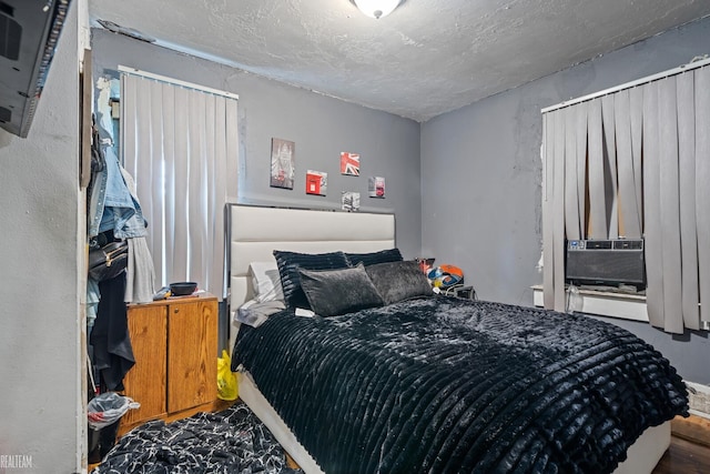 bedroom with a textured ceiling and cooling unit