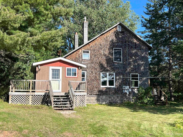 rear view of property featuring a yard and a wooden deck