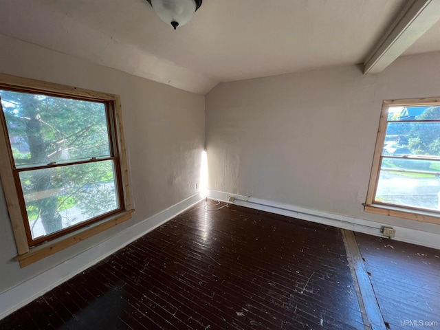 spare room with a wealth of natural light, dark wood-type flooring, and lofted ceiling with beams