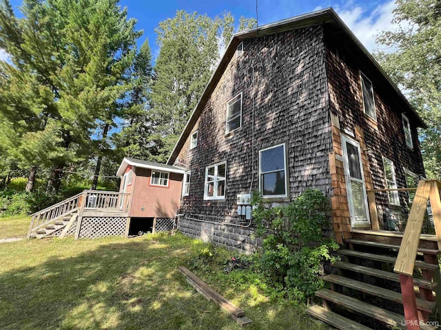 view of side of property featuring a wooden deck and a yard