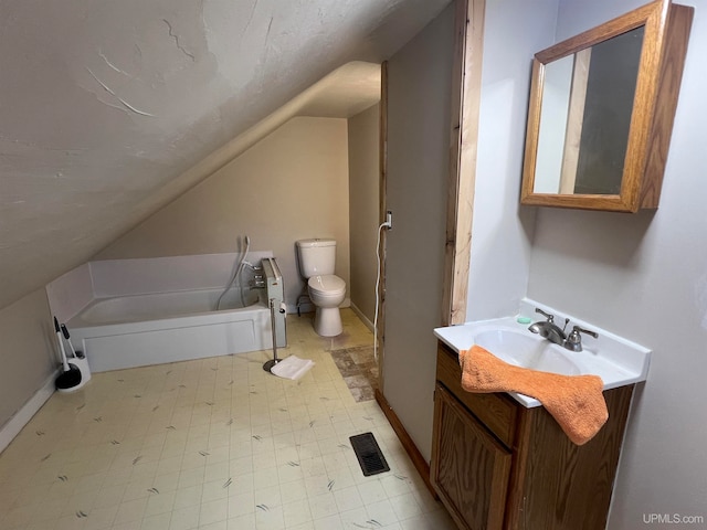 bathroom with a bathtub, toilet, vaulted ceiling, and vanity