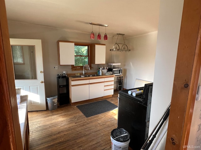 kitchen featuring hanging light fixtures, ornamental molding, electric range, white cabinetry, and light wood-type flooring