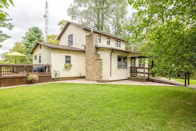 back of property with a wooden deck, a yard, and a patio area