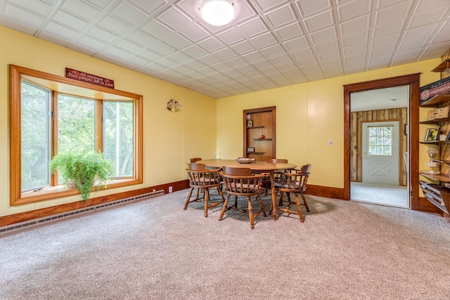 carpeted dining space with a baseboard radiator