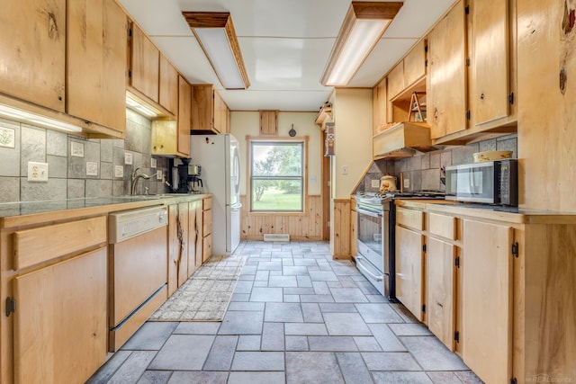 kitchen with custom exhaust hood, wood walls, appliances with stainless steel finishes, and decorative backsplash