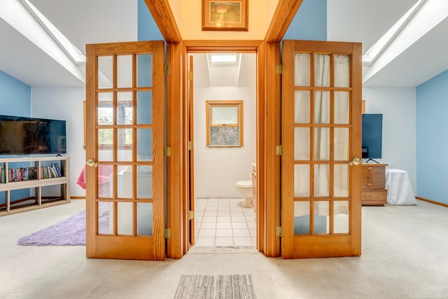 corridor featuring light carpet and a skylight