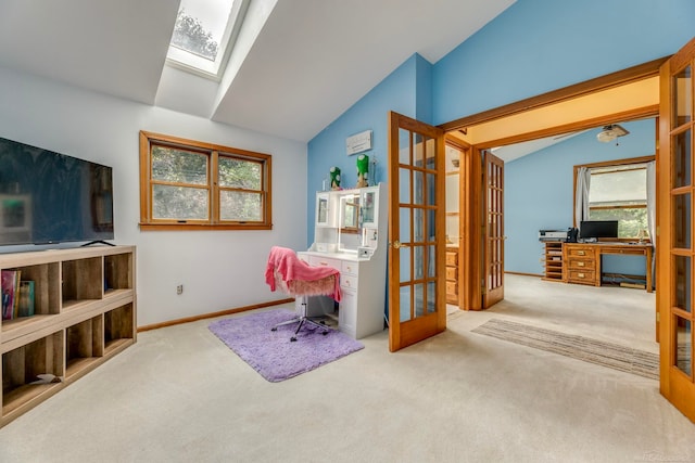 carpeted home office with a wealth of natural light and vaulted ceiling with skylight