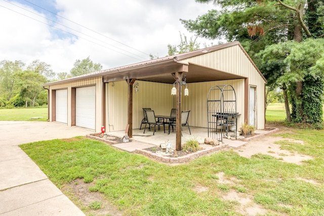 exterior space featuring a garage, an outbuilding, and a front yard