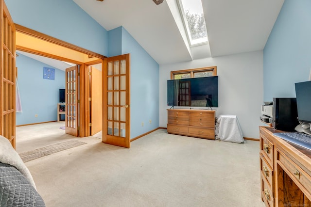 bedroom featuring light colored carpet, vaulted ceiling with skylight, and french doors