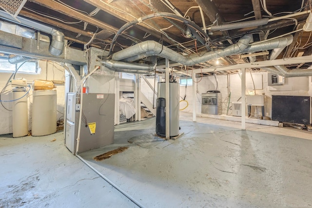 basement featuring electric panel, heating unit, and water heater