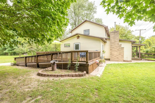 rear view of property featuring a deck and a lawn