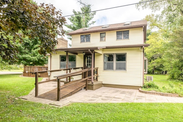 view of front of home with a wooden deck, a patio, and a front lawn