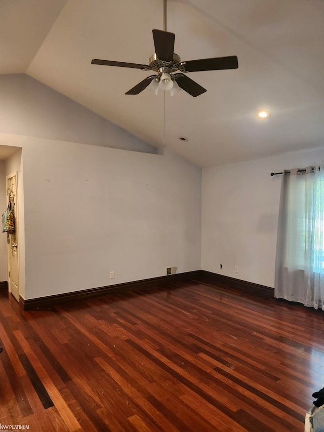 empty room featuring vaulted ceiling, dark hardwood / wood-style flooring, and ceiling fan