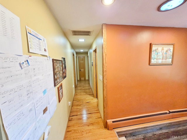 corridor featuring light wood-type flooring and a baseboard radiator