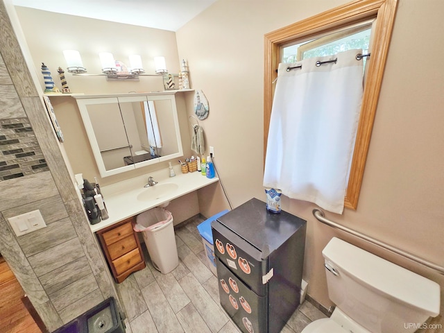 bathroom with toilet, hardwood / wood-style flooring, and sink