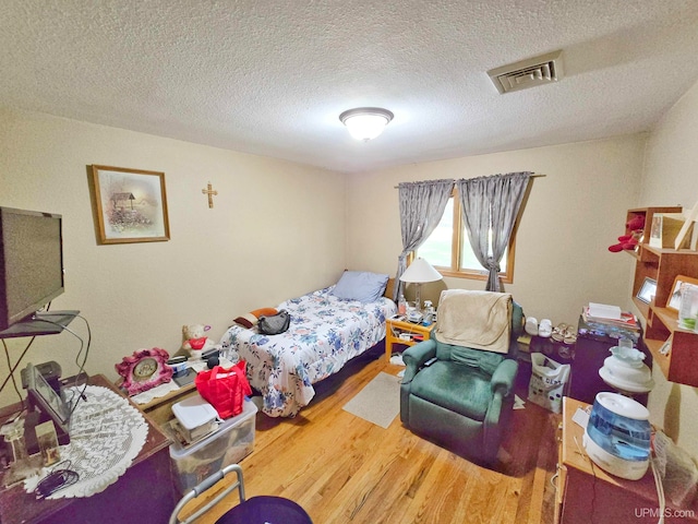 bedroom featuring a textured ceiling and wood-type flooring