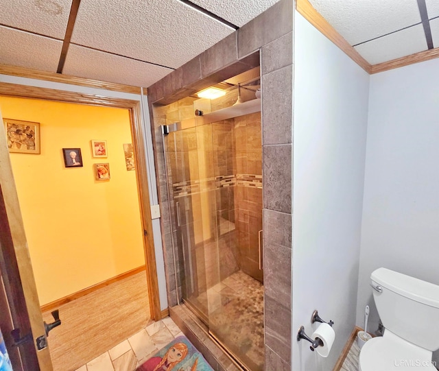 bathroom featuring tiled shower, crown molding, toilet, and hardwood / wood-style flooring