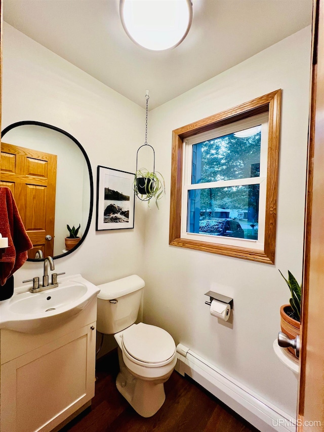 bathroom featuring vanity, toilet, a baseboard radiator, and hardwood / wood-style flooring