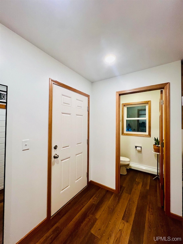 entryway with dark wood-type flooring and baseboard heating