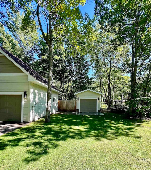 view of yard featuring a garage and an outdoor structure