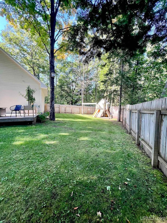 view of yard featuring a deck and a playground