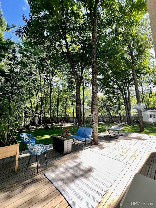 wooden terrace featuring a lawn and an outdoor fire pit