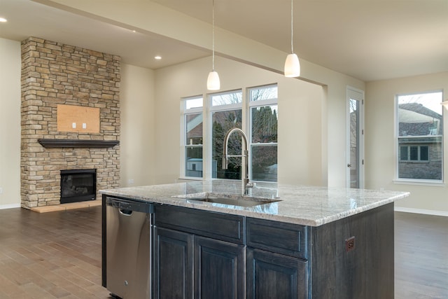 kitchen featuring dishwasher, a healthy amount of sunlight, sink, and a fireplace